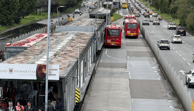 Operadores y usuarios en la entrada de una estacion del sistema TransMilenio