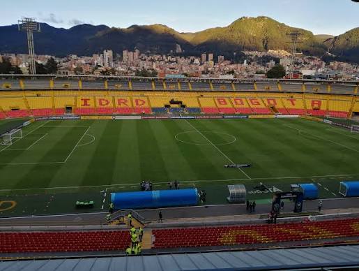 Gradas vacías y césped húmedo iluminado durante la revisión del estado de El Campín